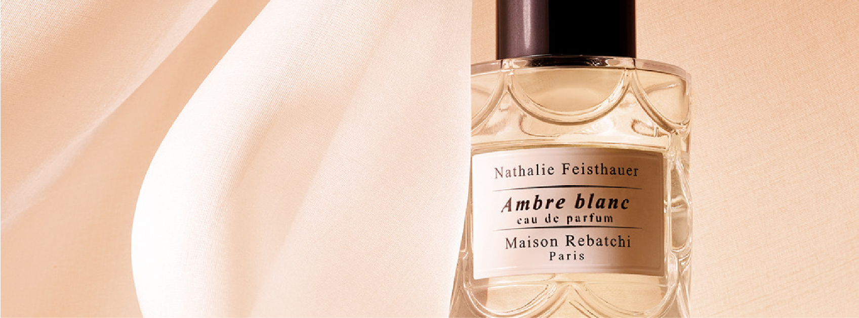 bottle of ambre blanc by maison rebatchi with pink silk