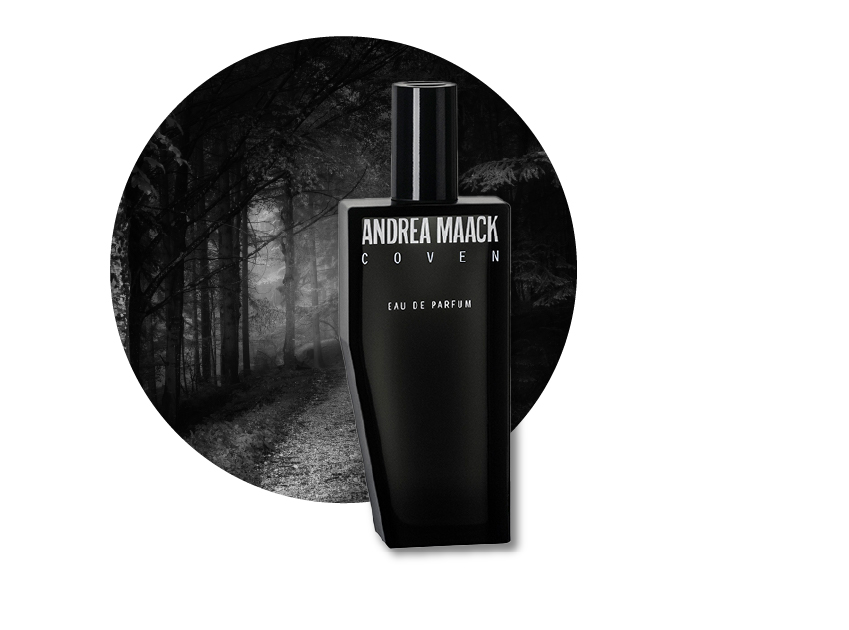 a bottle of coven perfume by andrea maack with a photo of a haunting forest